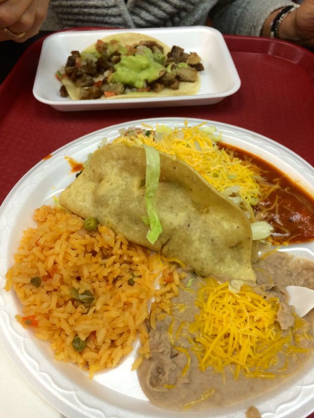 A Taco, Rice, and Beans accompanied by a Carnitas Soft Taco from Lauritas