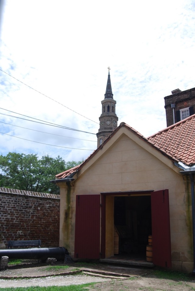 The spire of St. Philip's Episcopal Church rises above the Powder Magazine